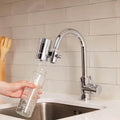 Filtre robinet EcoPro SMR installé sur un robinet de cuisine, remplissant une bouteille en verre