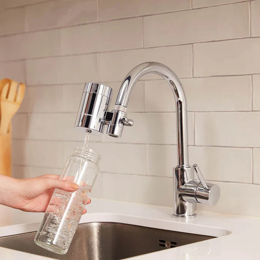 Filtre robinet EcoPro SMR installé sur un robinet de cuisine, remplissant une bouteille en verre