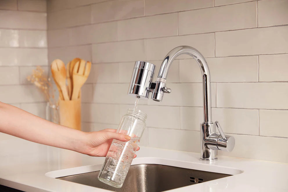 Verre d'eau filtré rempli depuis un robinet avec le filtre EcoPro SMR Tappwater